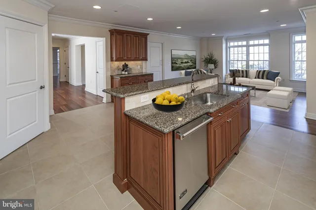 an open kitchen with granite countertop a sink and a refrigerator