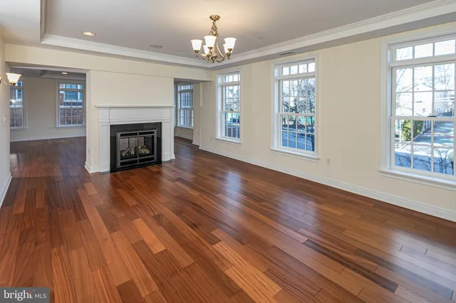 wooden floor fireplace and windows in an empty room