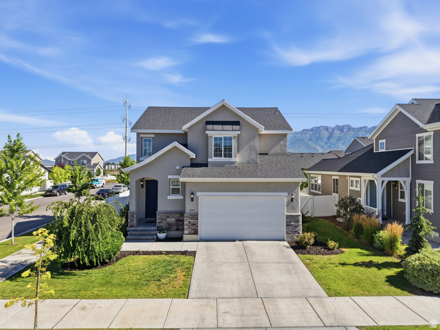 3244 West 1670th Street North Provo, UT 84601 - Photo 1 of 56 Stucco exterior residence featuring an attached two-car garage, a concrete driveway, and mature landscaping