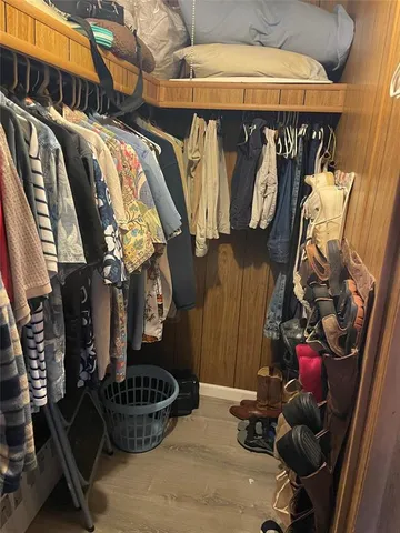 a view of walk in closet with clothes and shoes