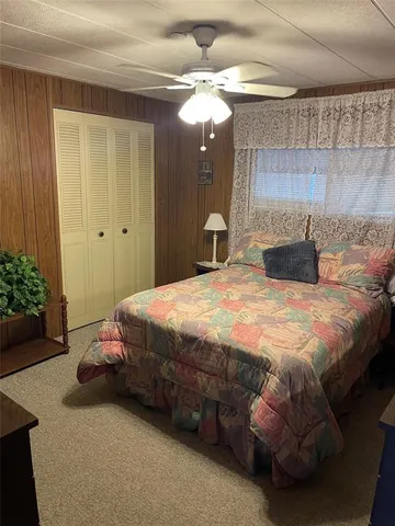 a bedroom with a bed a mirror and potted plant