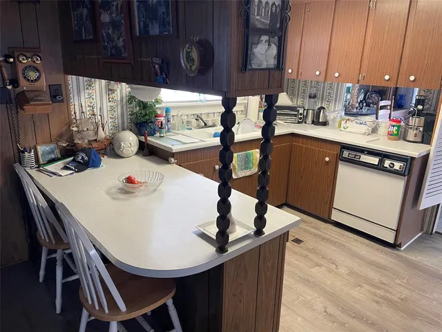 a kitchen with stainless steel appliances kitchen island a table chairs in it and wooden floors