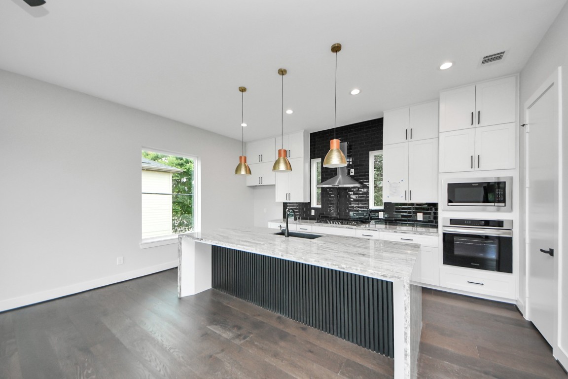 3419 Arlington Street Houston, TX 77018 - Photo 20 of 44 a large kitchen with granite countertop a large counter top a sink stainless steel appliances and cabinets