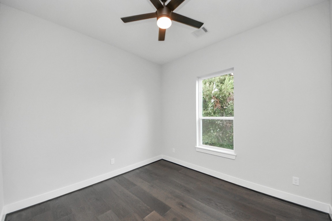 3419 Arlington Street Houston, TX 77018 - Photo 33 of 44 an empty room with wooden floor ceiling fan and windows