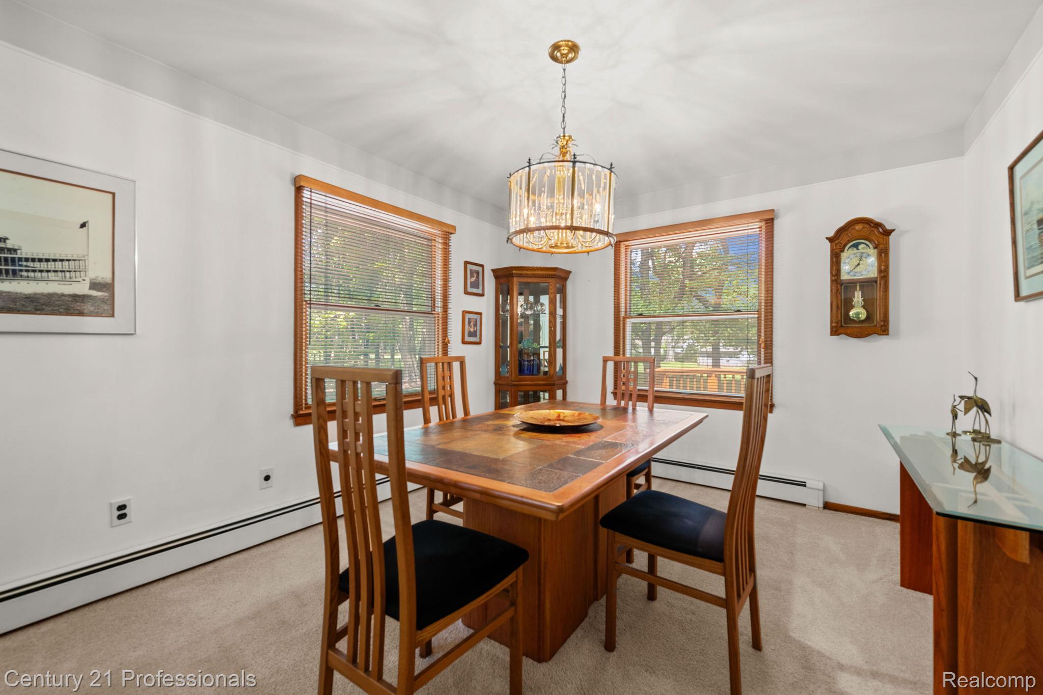 8638 Stone Road Algonac, MI 48001 - Photo 33 of 70 Dining space with light carpet, baseboard heating, and hanging lights