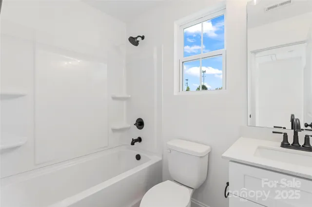 a white toilet sitting next to a bath tub
