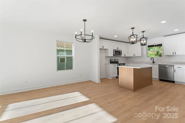 a kitchen with stainless steel appliances granite countertop a sink a stove and a window