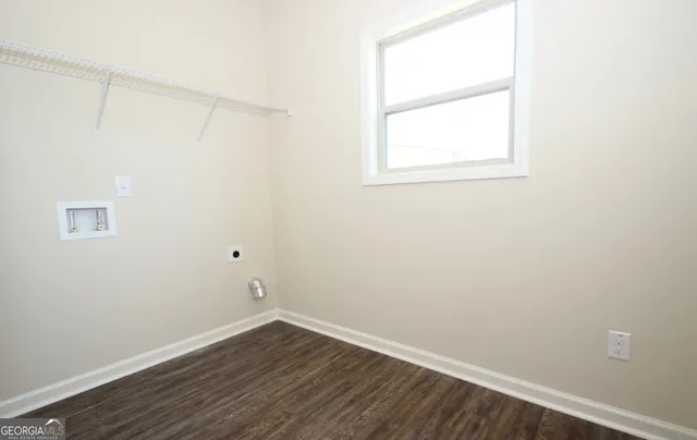 an empty room with a window and wooden floor