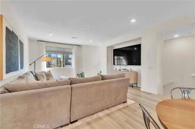 a living room with furniture kitchen view and a flat screen tv