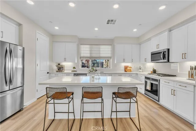 a kitchen with white cabinets and white appliances