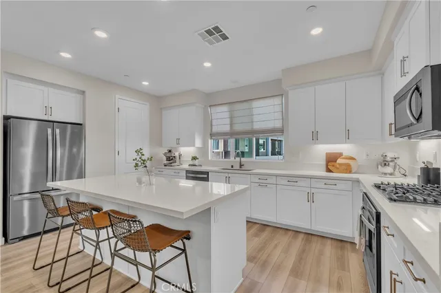 a kitchen with granite countertop white cabinets and stainless steel appliances