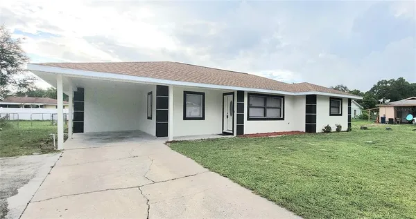 a front view of a house with a garden and yard