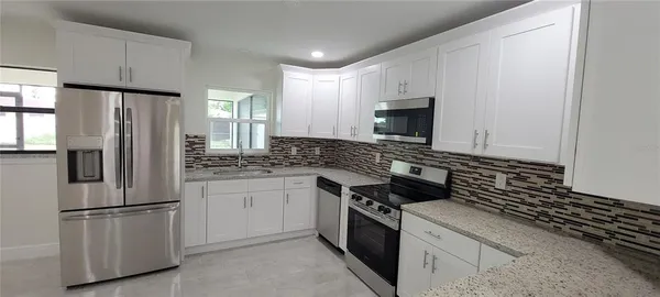 a bathroom with a granite countertop sink mirror vanity and toilet