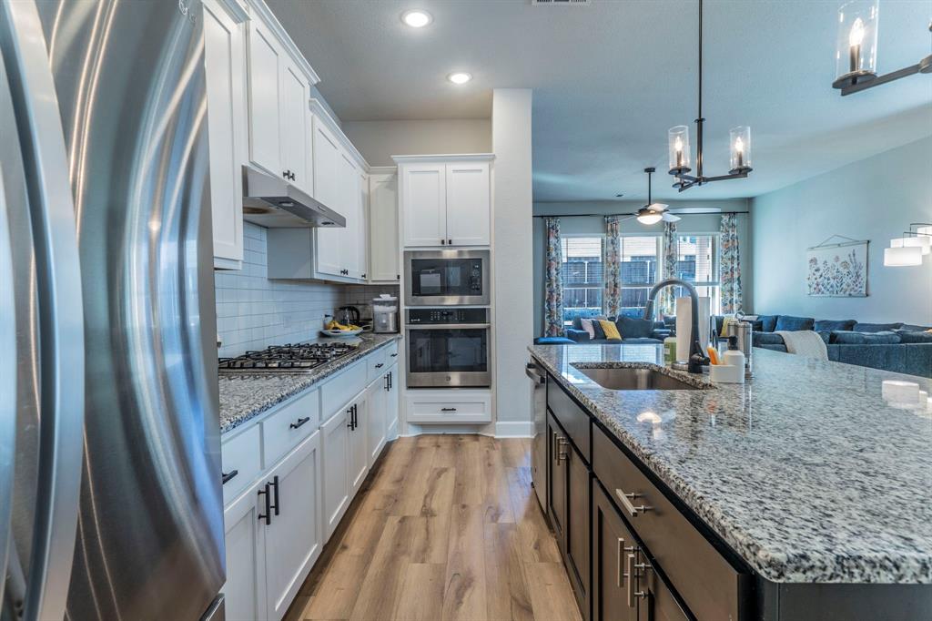 1885 Arbor Drive Forney, TX 75126 - Photo 33 of 33 Kitchen with appliances with stainless steel finishes, open floor plan, white cabinetry, pendant lighting, and recessed lighting