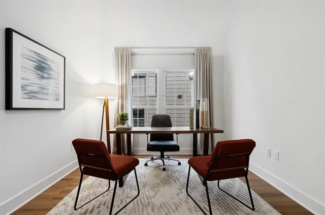 a view of a workspace room with furniture and wooden floor