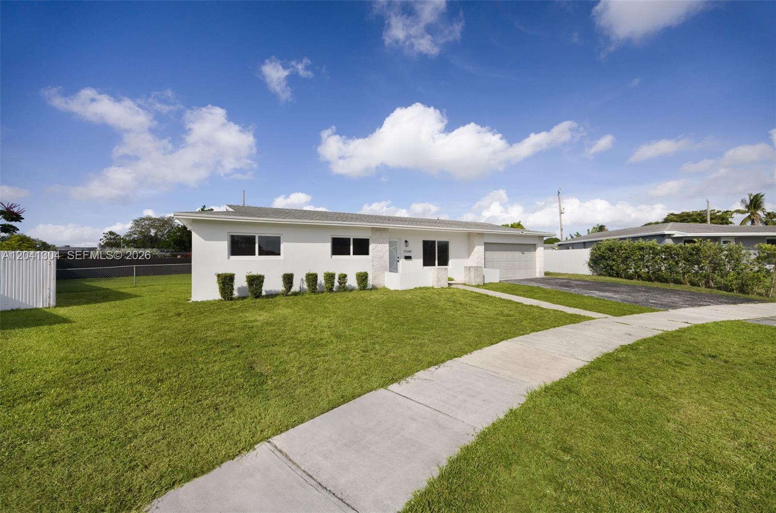 10340 Southwest 157th Street Miami, FL 33157 - Photo 3 of 24 Freshly updated exterior with clean architectural lines, a spacious front lawn, and an extended driveway. The expansive yard creates a welcoming first impression.