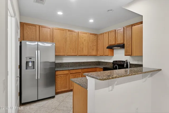 a kitchen with stainless steel appliances granite countertop a refrigerator and a stove