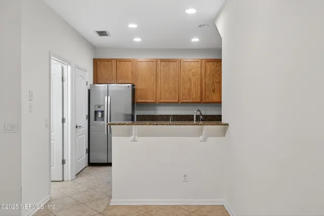 a kitchen with granite countertop wood cabinets and stainless steel appliances