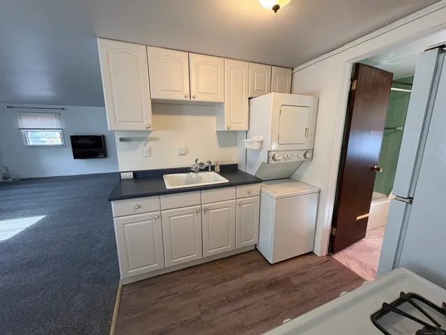 a kitchen with a sink a refrigerator and cabinets
