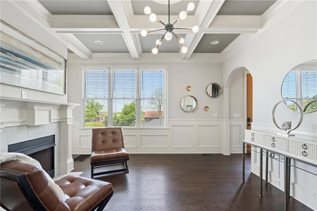 a living room with furniture chandelier and a large window