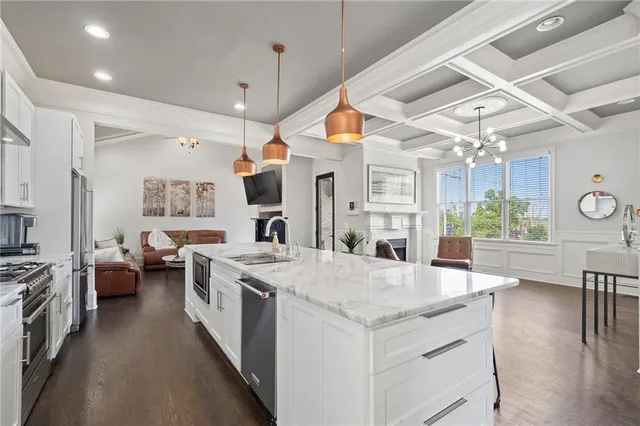 a kitchen with a stove a sink a refrigerator and a fireplace