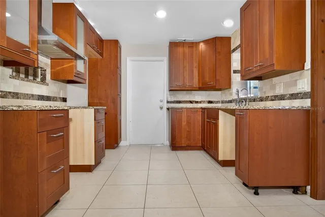 a kitchen with stainless steel appliances granite countertop a stove a refrigerator and a oven