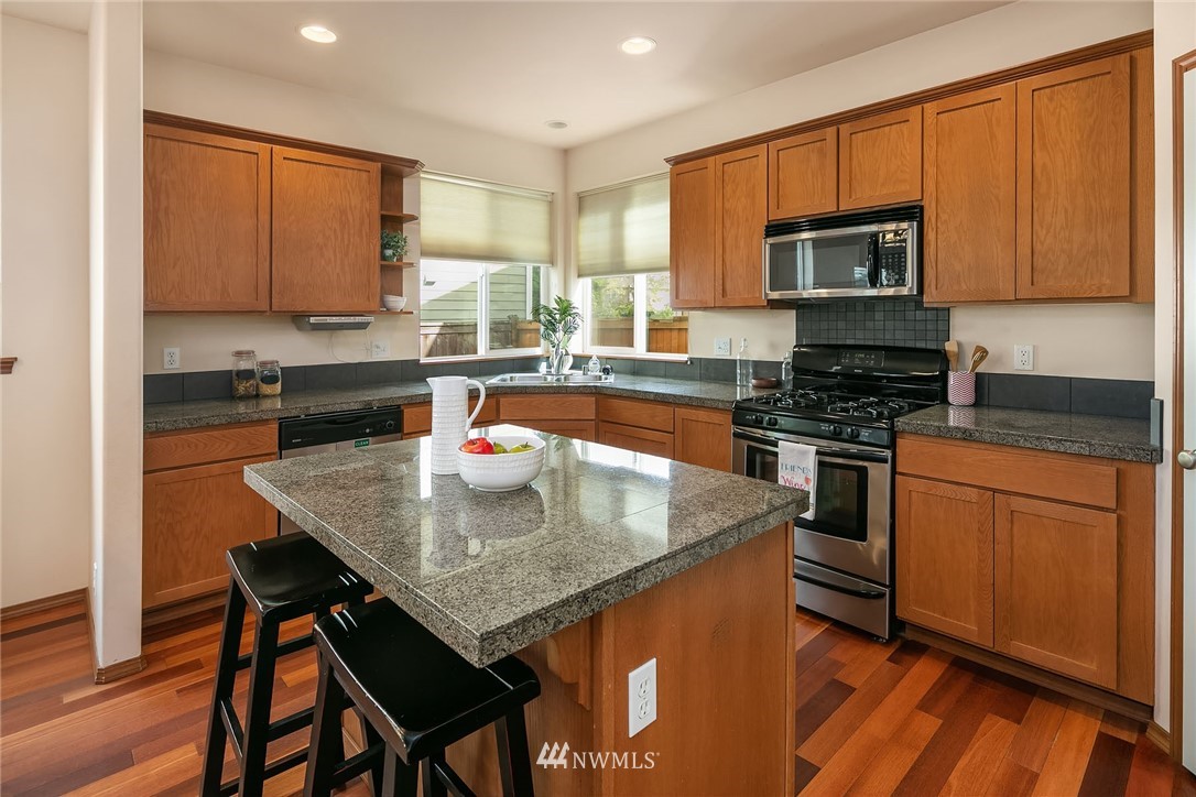 3425 183rd Place Southeast Bothell, WA 98012 - Photo 11 of 25 a kitchen with stainless steel appliances granite countertop a stove a sink dishwasher a microwave oven with granite countertops and cabinets