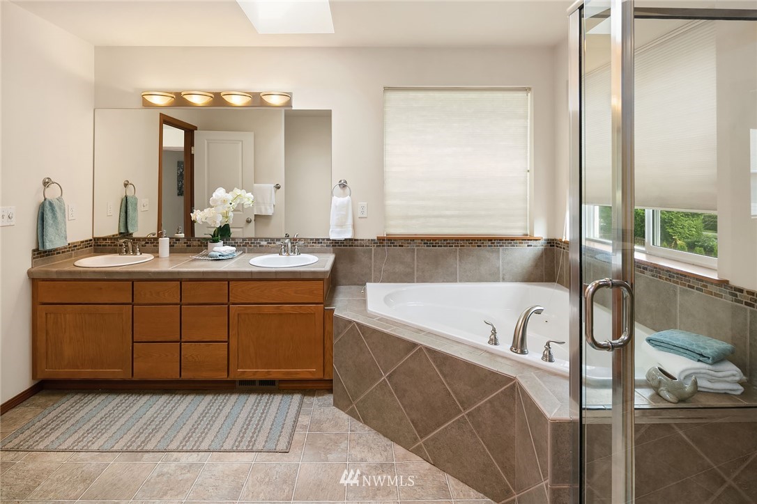 3425 183rd Place Southeast Bothell, WA 98012 - Photo 23 of 25 a spacious bathroom with a tub a double vanity sink and mirror