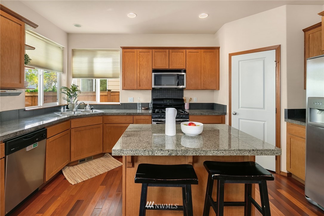 3425 183rd Place Southeast Bothell, WA 98012 - Photo 9 of 25 a kitchen with granite countertop kitchen island stainless steel appliances a sink stove and cabinets
