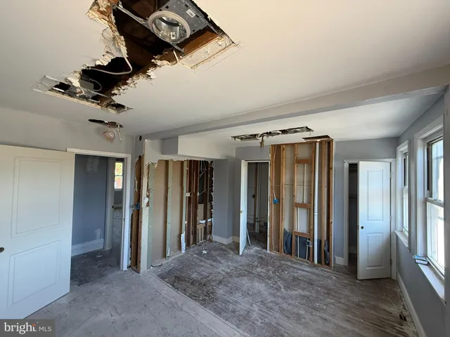 a view of hallway with windows and a refrigerator