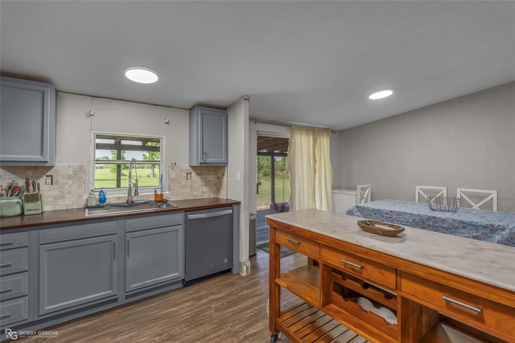 10660 Bowen Road Vivian, LA 71082 - Photo 9 of 27 a kitchen with stainless steel appliances granite countertop a sink a stove cabinets and wooden floor