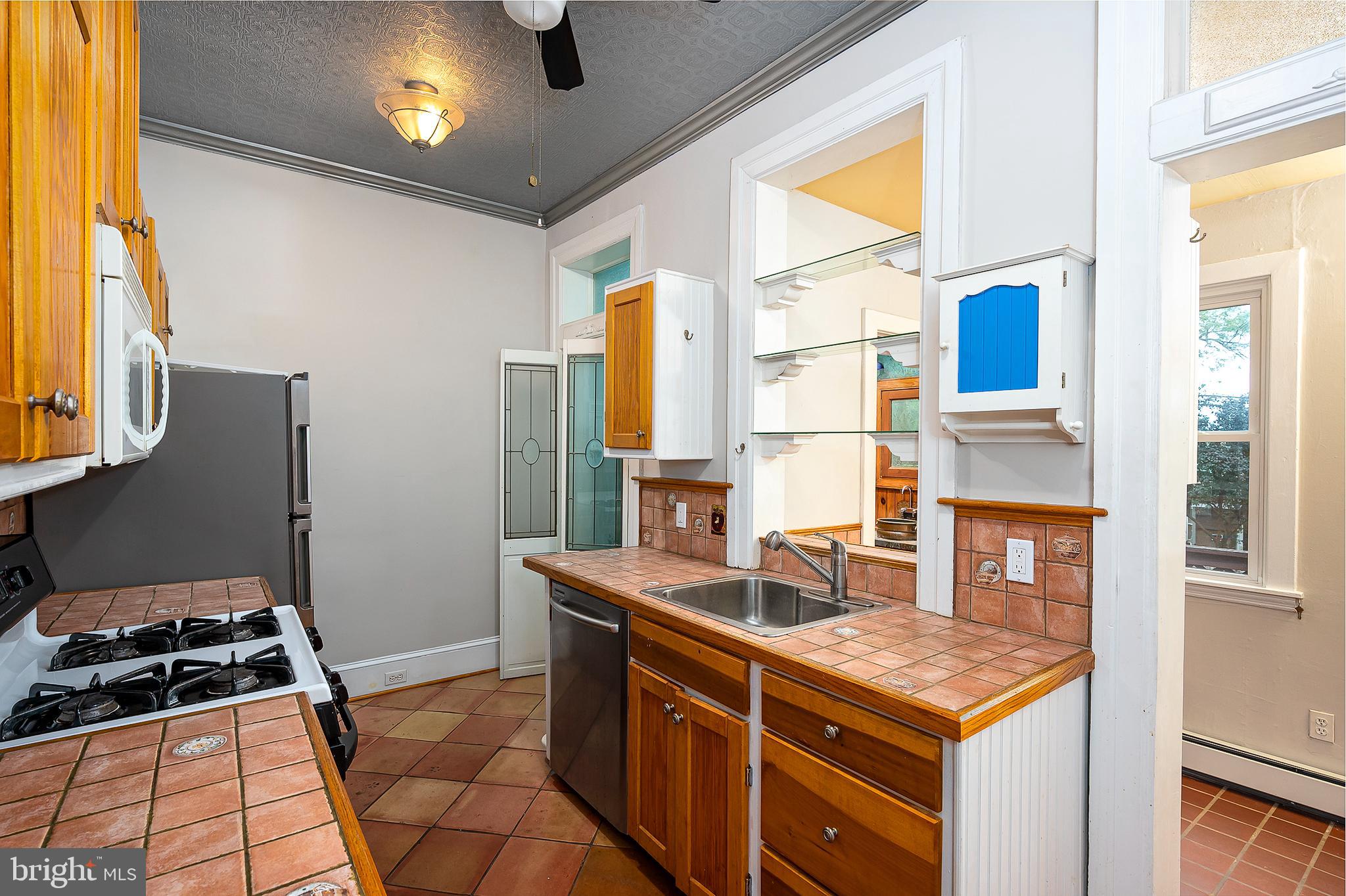 4018 Roland Avenue Baltimore, MD 21211 - Photo 12 of 27 a kitchen with stainless steel appliances granite countertop a sink stove and refrigerator