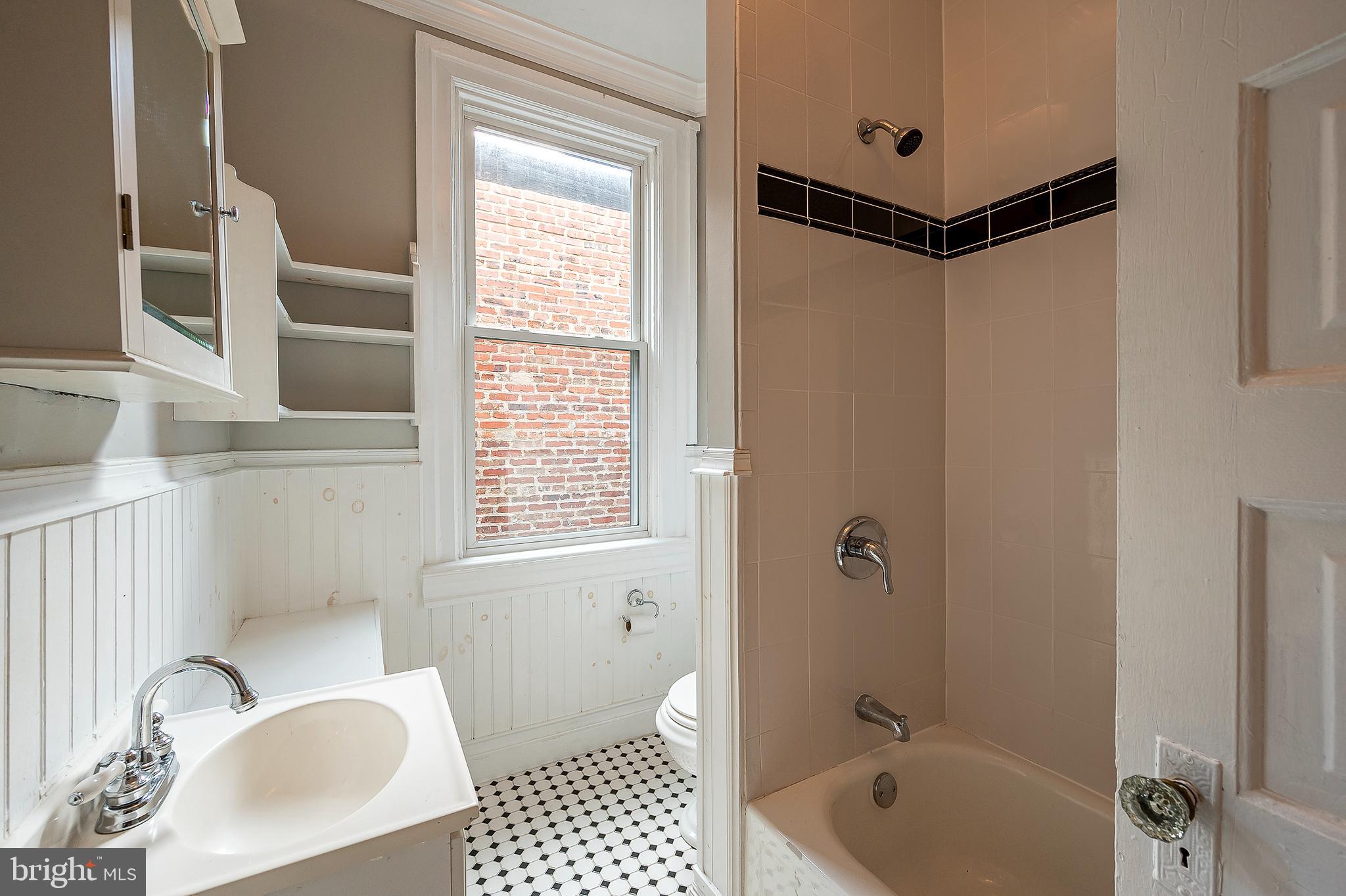 4018 Roland Avenue Baltimore, MD 21211 - Photo 19 of 27 a bathroom with a bathtub shower sink and toilet