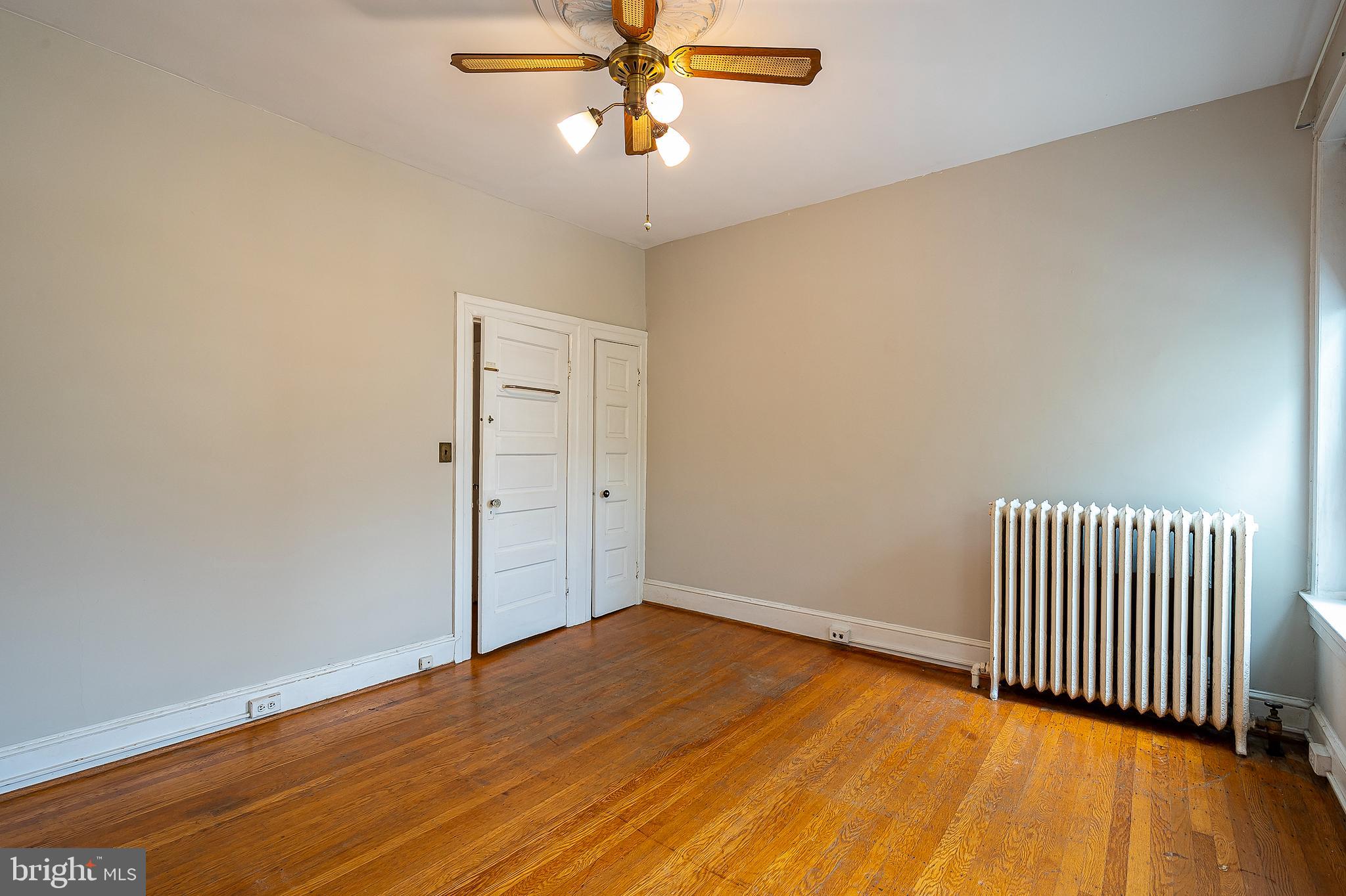 4018 Roland Avenue Baltimore, MD 21211 - Photo 21 of 27 an empty room with wooden floor and fan