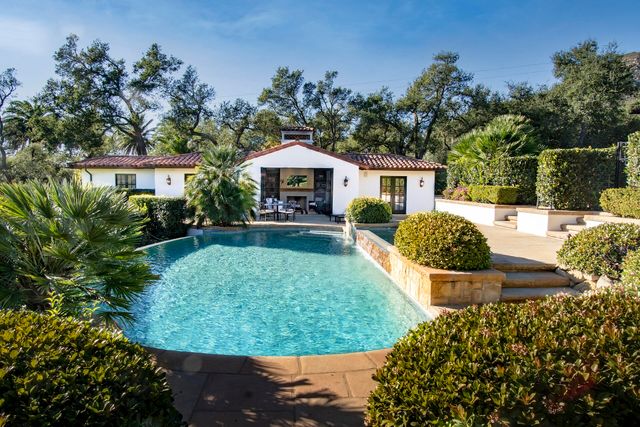 a kitchen with granite countertop a refrigerator a sink a stove and cabinets
