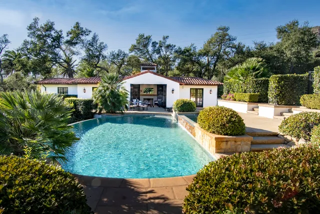 a kitchen with granite countertop a refrigerator a sink a stove and cabinets