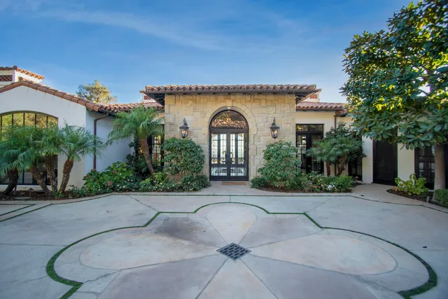 a dining room with wooden floor a chandelier a glass table and chairs
