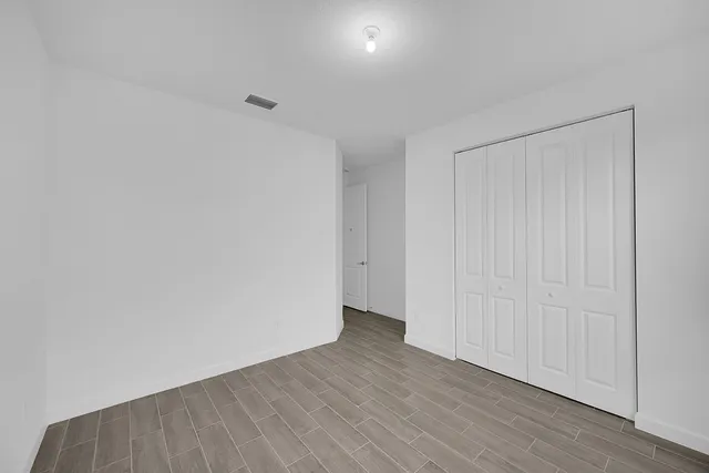 a view of an empty room with wooden floor