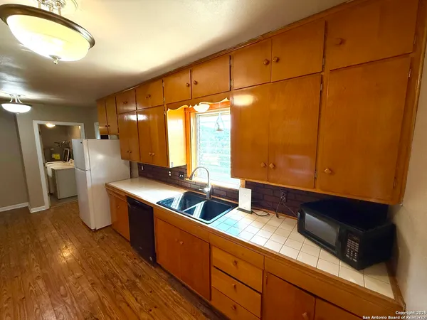 a kitchen with stainless steel appliances granite countertop a sink a stove and a refrigerator