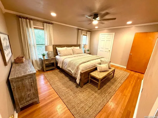 a spacious bedroom with a bed and wooden floor