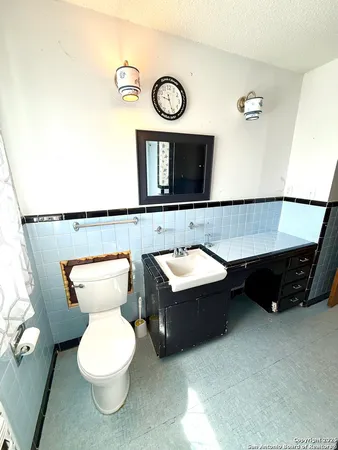 a bathroom with a toilet a sink and a mirror