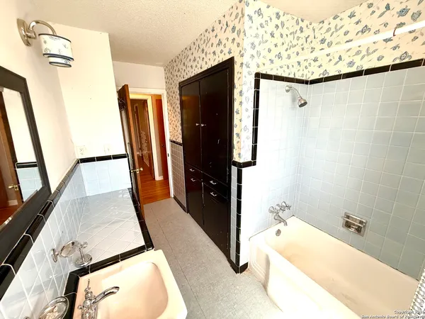 a bathroom with a tub sink and shower curtain