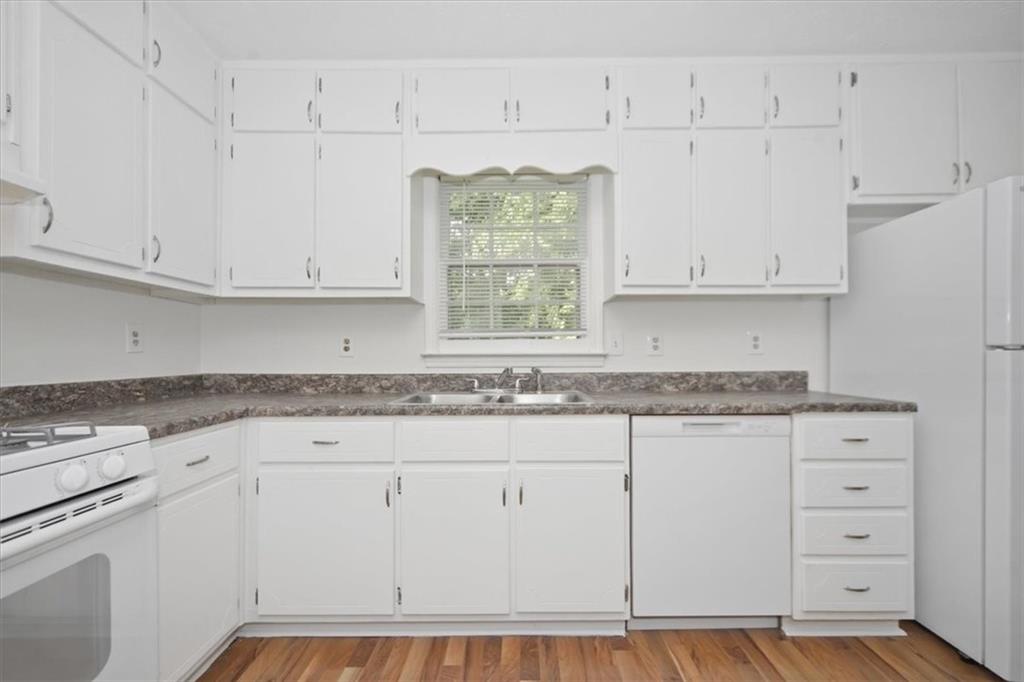 1496 Cherry Hill Road Southwest Conyers, GA 30094 - Photo 7 of 32 a kitchen with granite countertop white cabinets and a stove