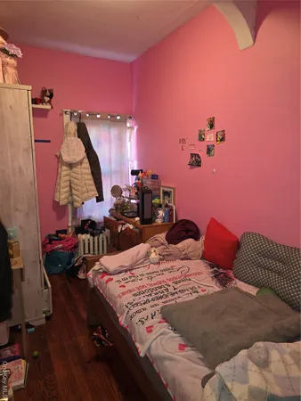 a bed sitting in a bedroom next to a window