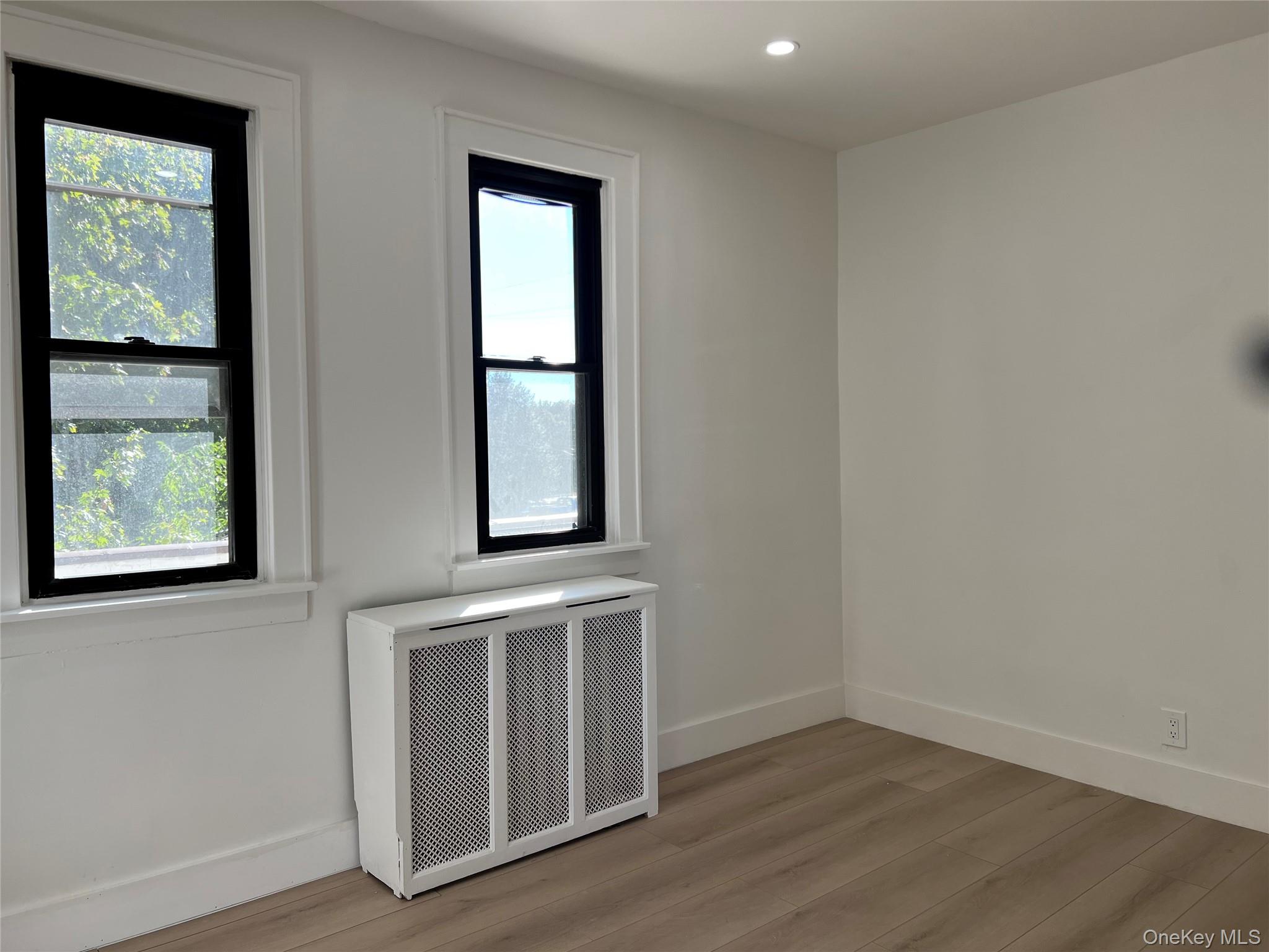 28 Walt Whitman Road Huntington Station, NY 11746 - Photo 11 of 17 an empty room with wooden floor and windows