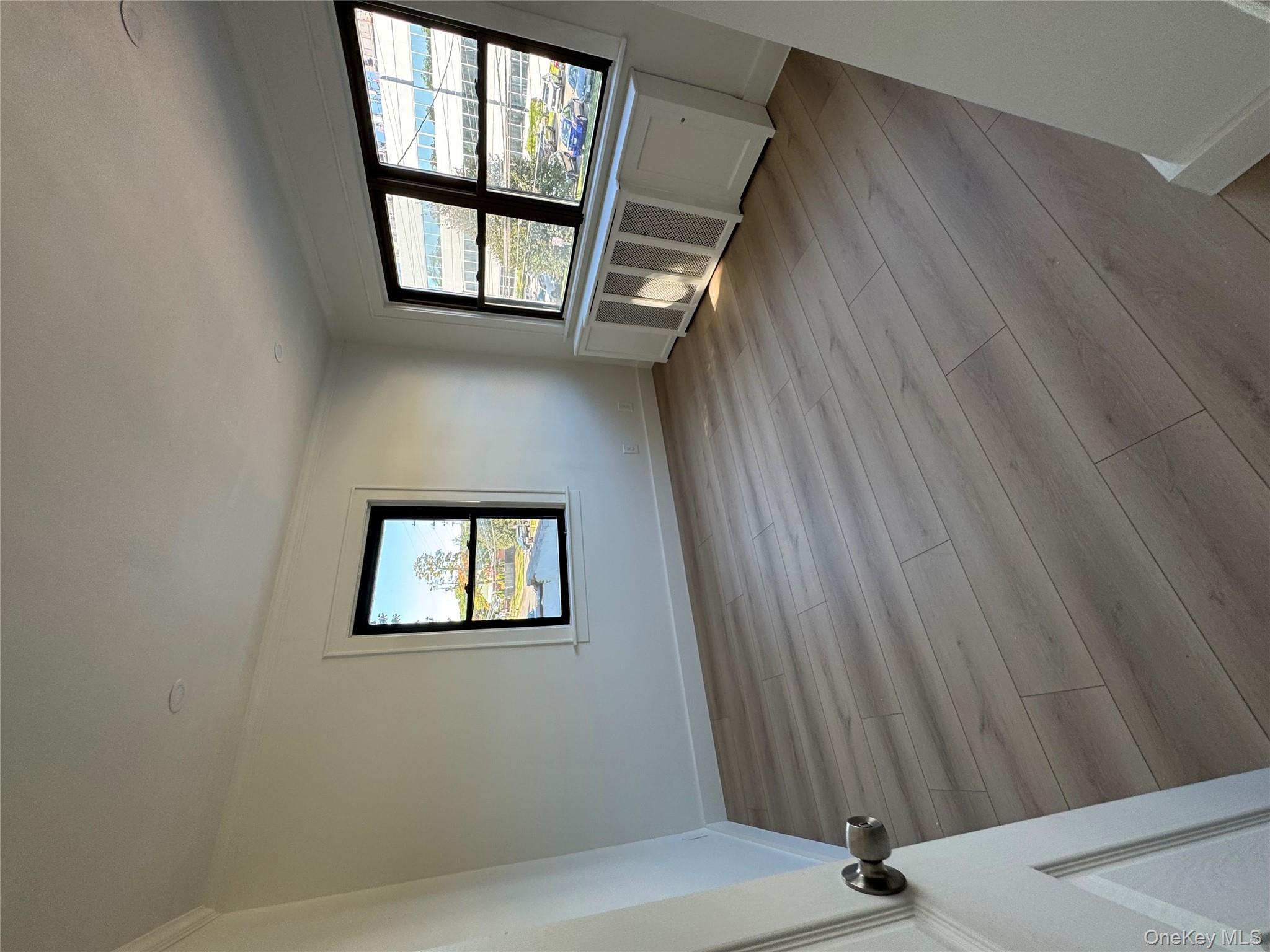 28 Walt Whitman Road Huntington Station, NY 11746 - Photo 12 of 17 an empty room with wooden floor and windows