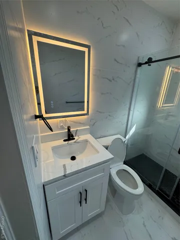 a bathroom with a sink mirror vanity and toilet