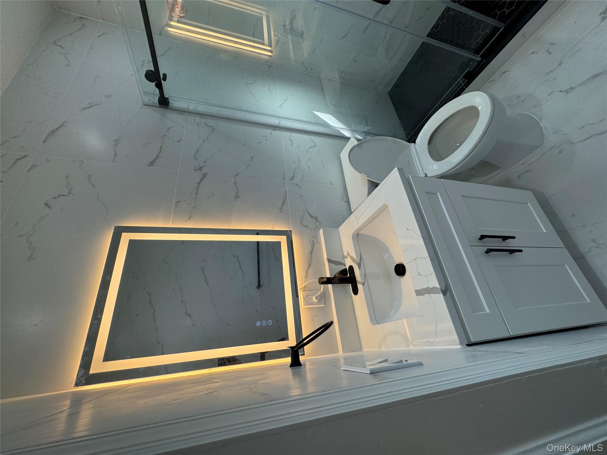 28 Walt Whitman Road Huntington Station, NY 11746 - Photo 4 of 17 a bathroom with a sink mirror vanity and toilet