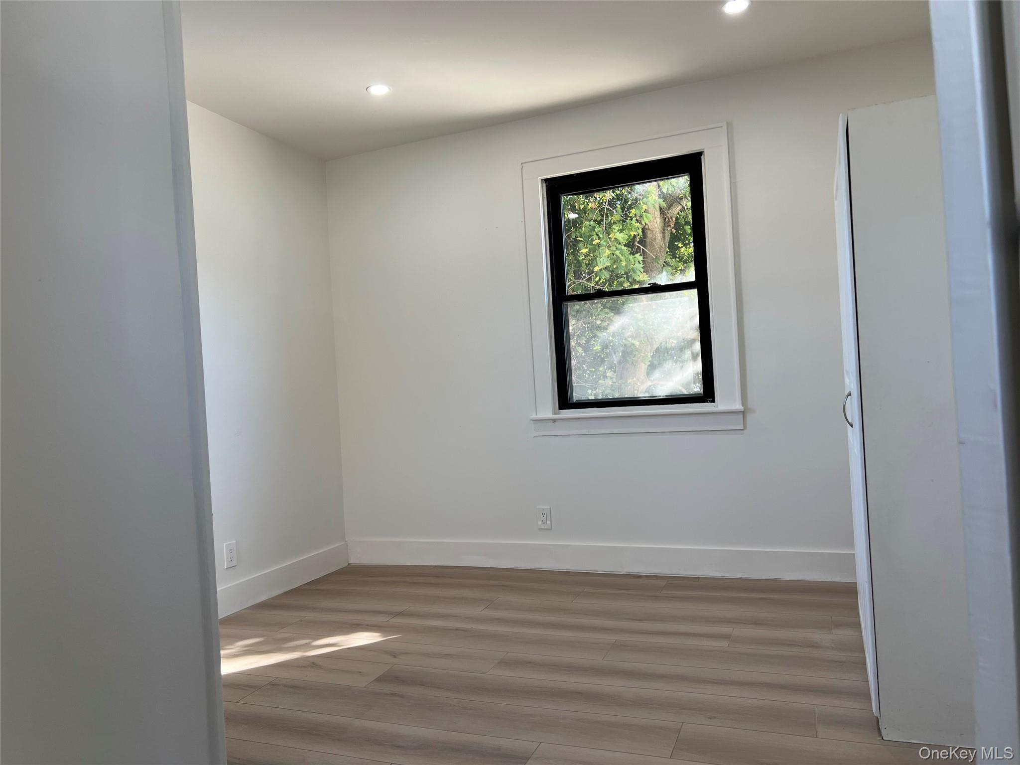 28 Walt Whitman Road Huntington Station, NY 11746 - Photo 7 of 17 wooden floor in an empty room with a window