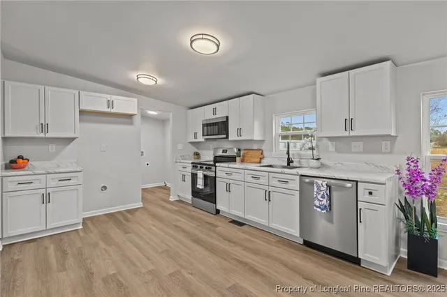 a kitchen with granite countertop white cabinets and white appliances